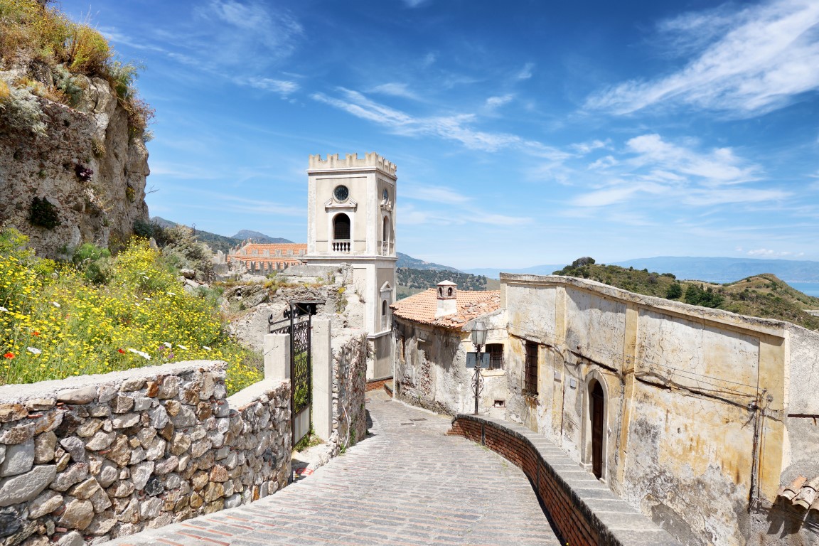 Blick von oben auf einen Steinpflasterweg, der zur Kirche von San Nicolo