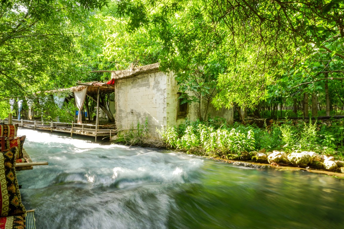 Der von grüner Vegetation umgebene Fluss Beyaz Su in Midyat