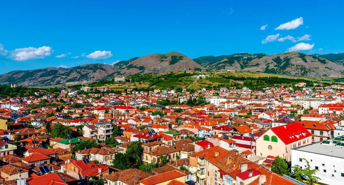 Panoramablick auf Korça, Albanien, mit roten Ziegeldächern und Bergkulisse