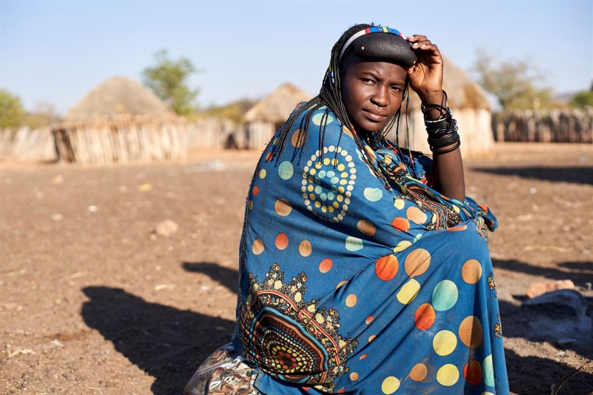 Porträt einer Muhacaona-Frau in ihrem traditionellen bunten Kleid, Oncocua, Angola