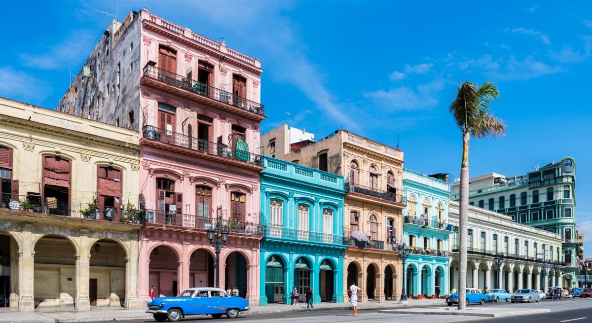 Die Hauptstraße in Havanna „Calle Paseo de Marti“,  restaurierten Häuserfronten und Oldtimer