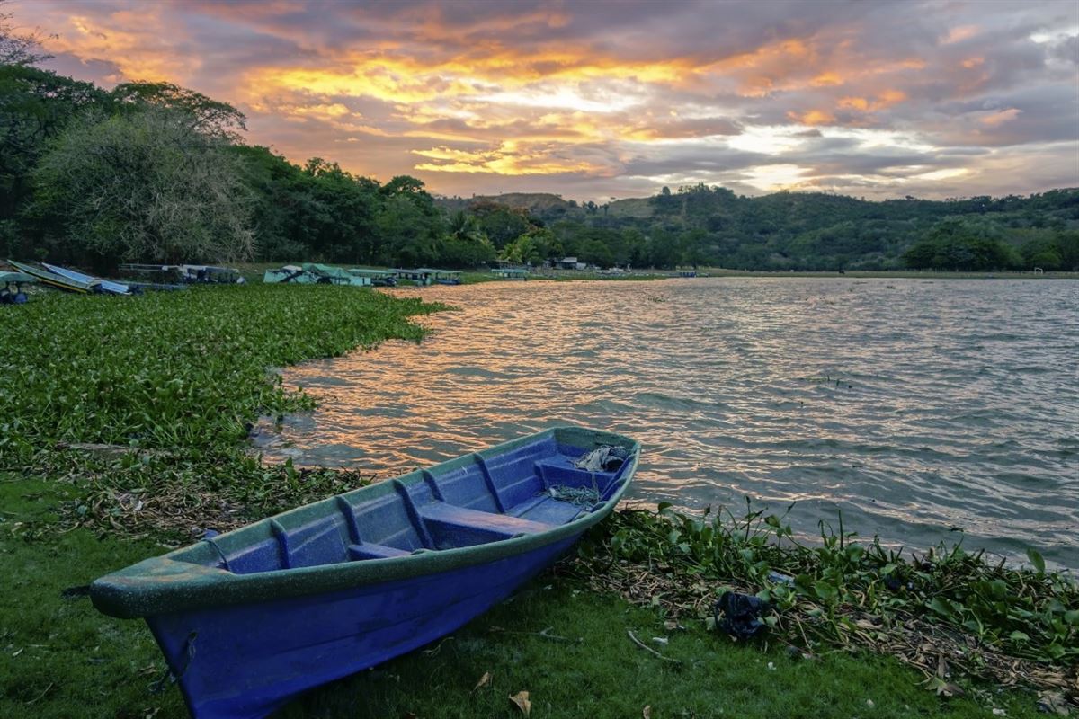 Blaues Fischerboot am Ufer des schönen Suchitlan-Sees  in der Nähe der Stadt Suchitoto in El Salvador