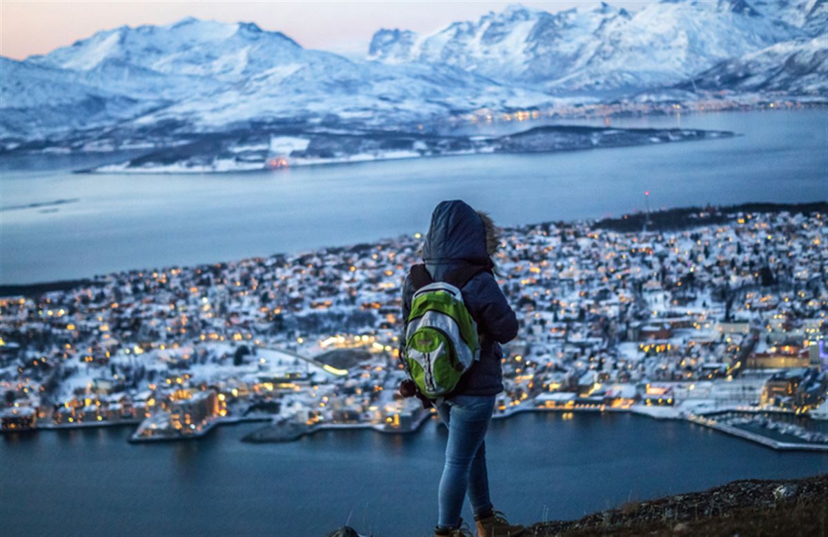 Reisende auf dem Gipfel des Berges in Tromsø im Winter