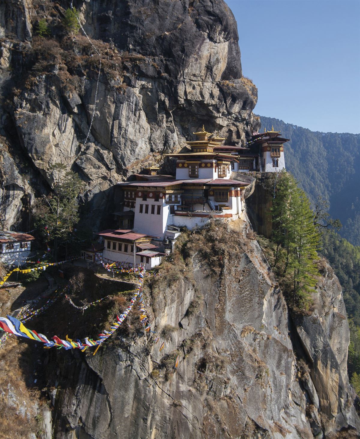 Bhutan: Häuser im und am Fels
